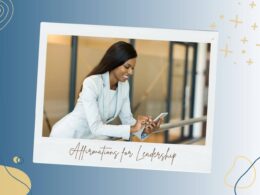 A confident woman in a light blue suit smiles while looking at her smartphone, standing in a modern office environment. The image is bordered by abstract shapes and patterns, with the phrase "Affirmations for Leadership" written in cursive underneath.